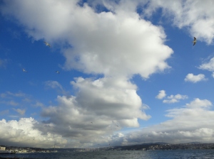 White clouds and blue sky above a strip of the Bosphorus and the Asian shore